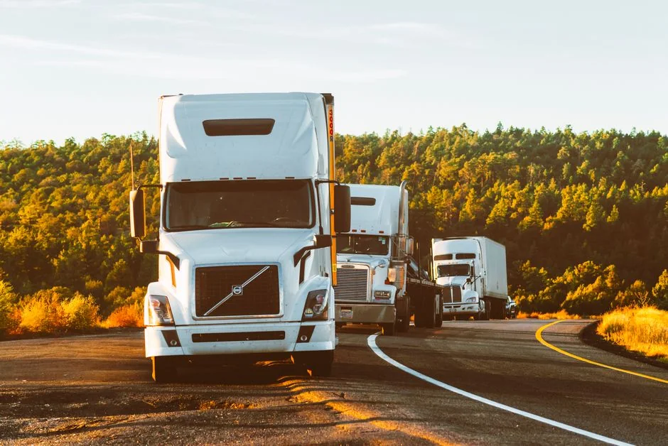 A fleet of semi trucks travelling on a highway