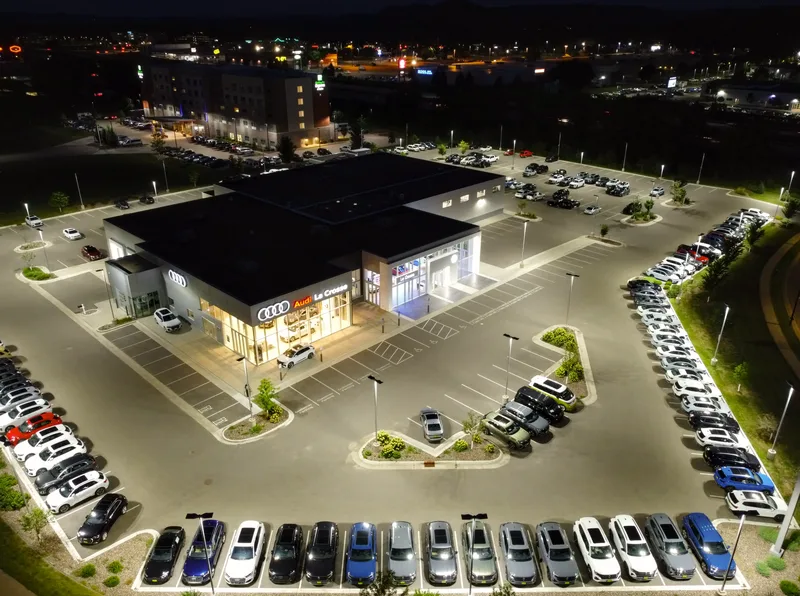 Car dealership showroom and inventory lot at night