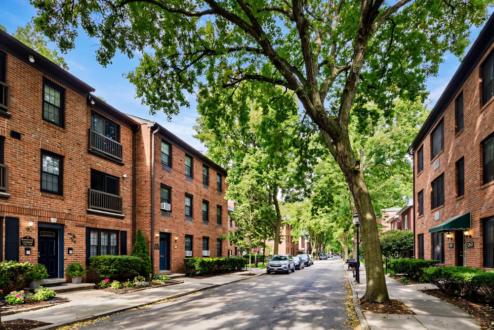 Brick low-rise rental apartment buildings on a tree-lined street